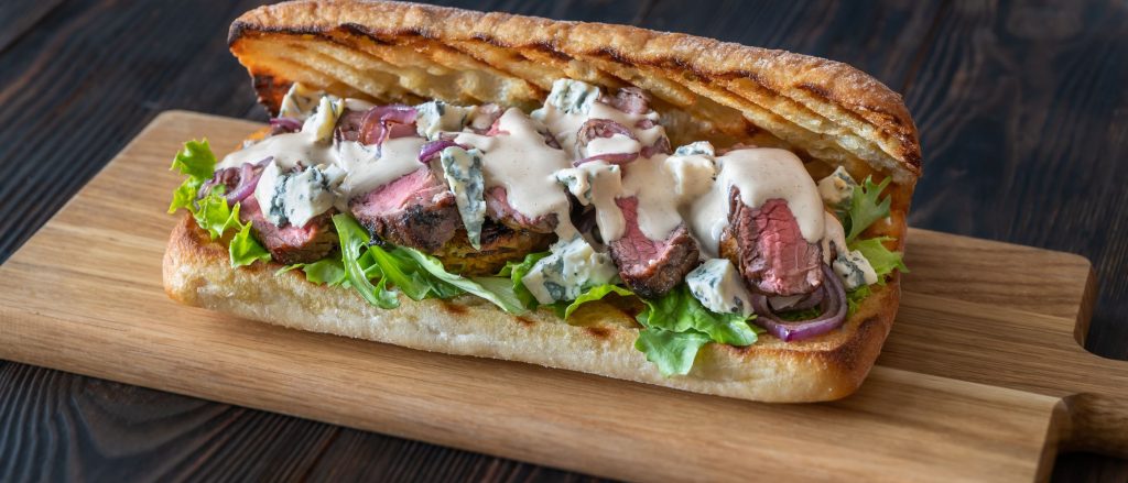 Grilled beef spiedies served on toasted hoagie buns with a tangy Italian dressing spread.