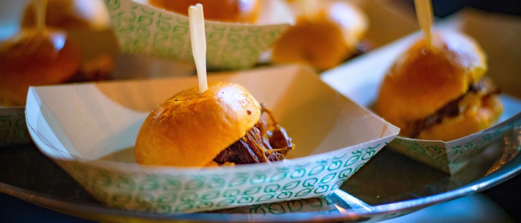 Slow-cooked BBQ brisket sliders with coleslaw on buns.